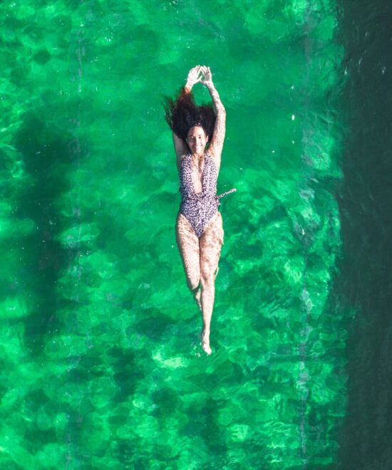 Frau schwimmt im chlorfreien Naturschwimmteich im Hotel Falkenstein