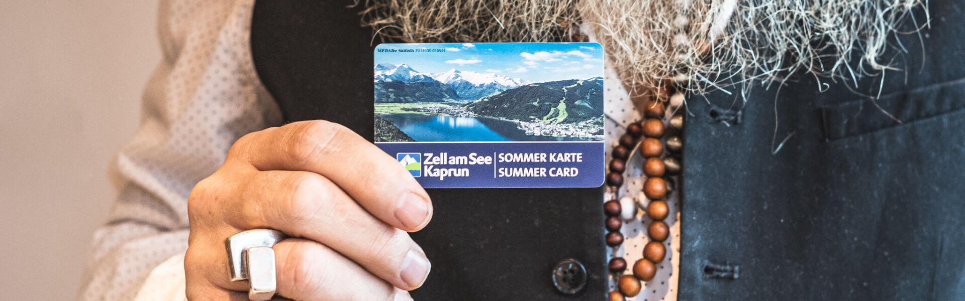 Mann hält die Zell am See Kaprun Sommercard in die Kamera
